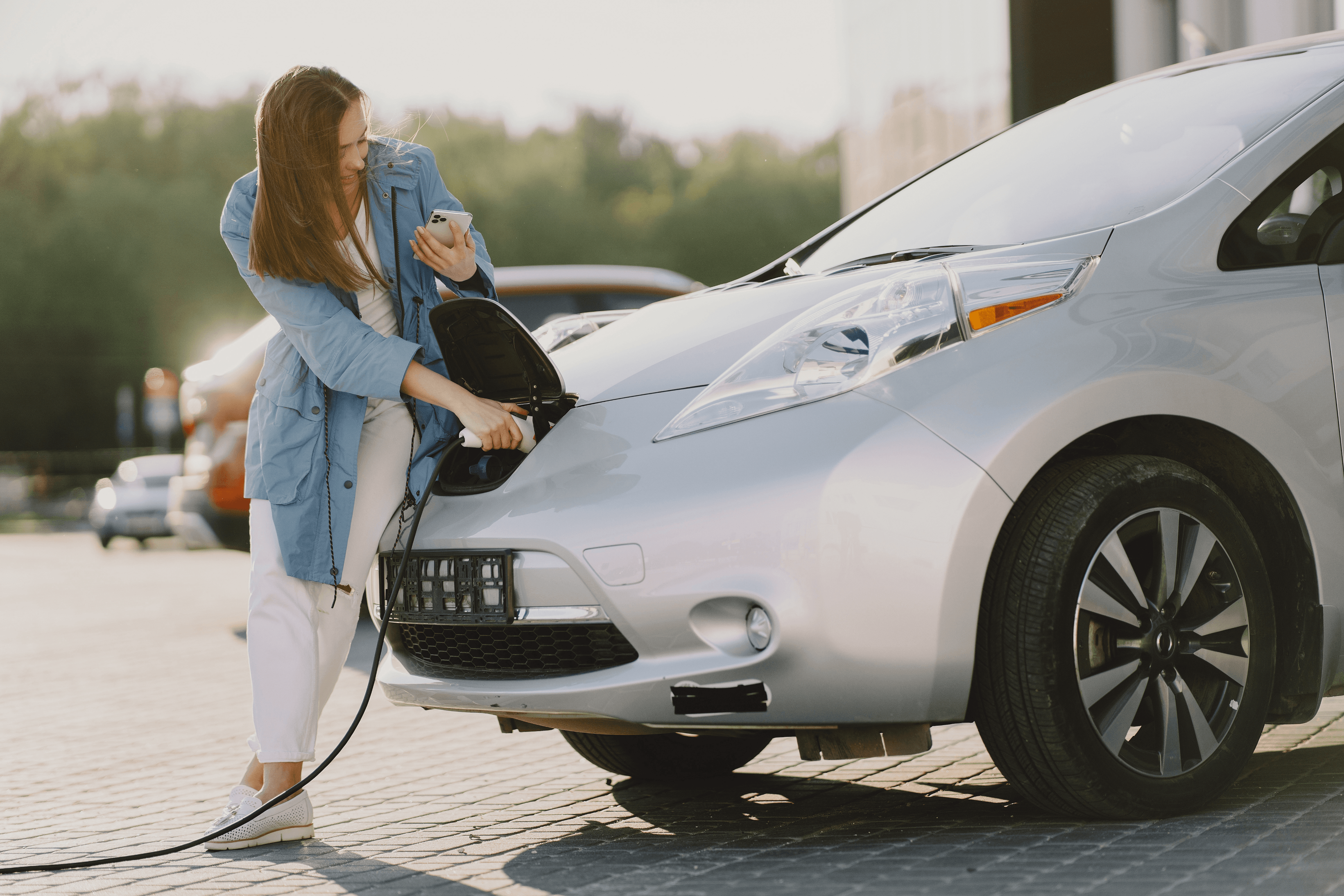 Een een vrouw die haar elektrische auto oplaadt